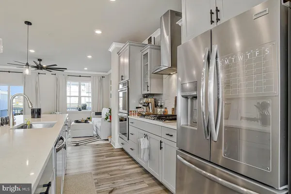 a large kitchen with a refrigerator a sink and white cabinets