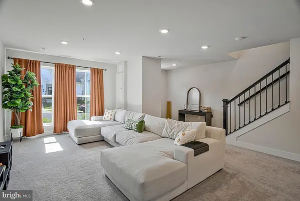 a living room with furniture and potted plants