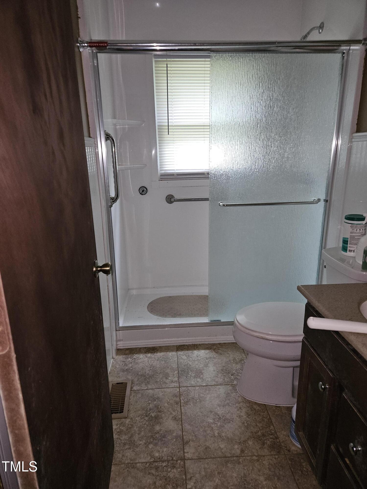 934 Shady Lawn Road Chapel Hill, NC 27514 - Photo 6 of 8 a bathroom with a granite countertop shower and a toilet