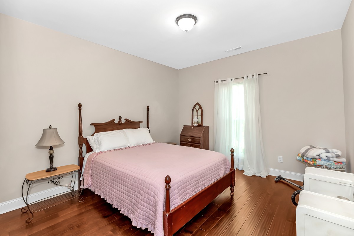 247 Mabel Hill Road Toney, AL 35773 - Photo 21 of 29 a bedroom with a bed and wooden floor
