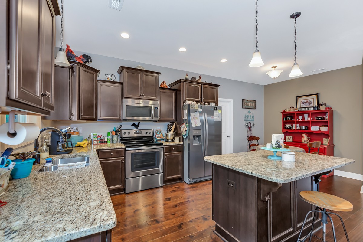 247 Mabel Hill Road Toney, AL 35773 - Photo 8 of 29 a kitchen with stainless steel appliances granite countertop a stove refrigerator and cabinets