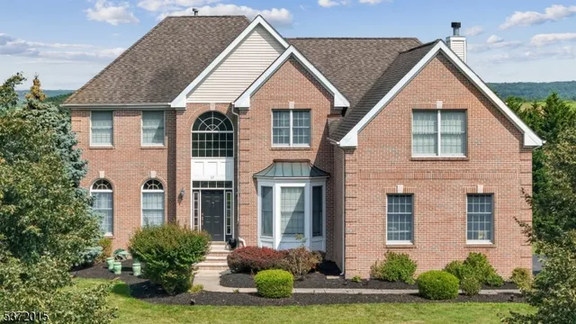 a front view of a house with yard and green space