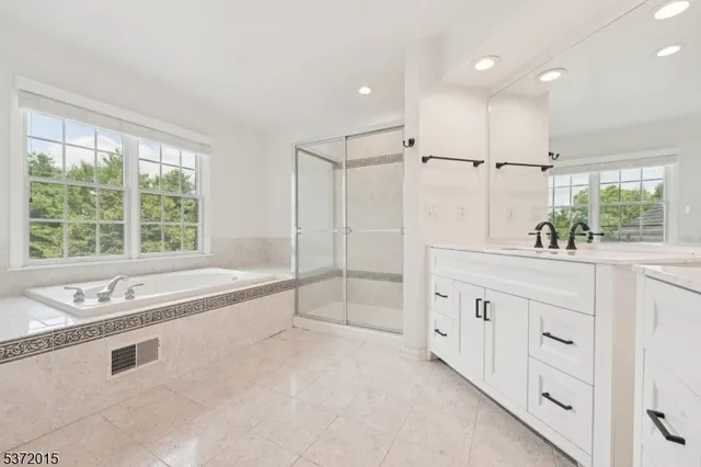 a spacious bathroom with sinks mirror and a bathtub