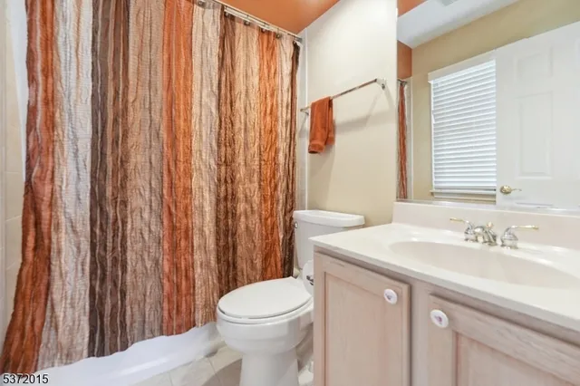a bathroom with a sink a toilet and shower curtain