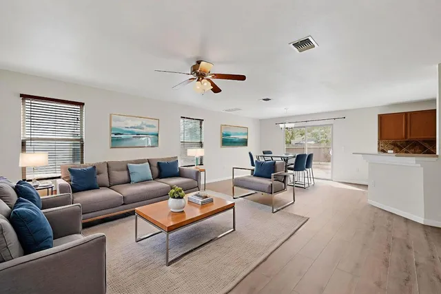 a living room with furniture flat screen tv and windows