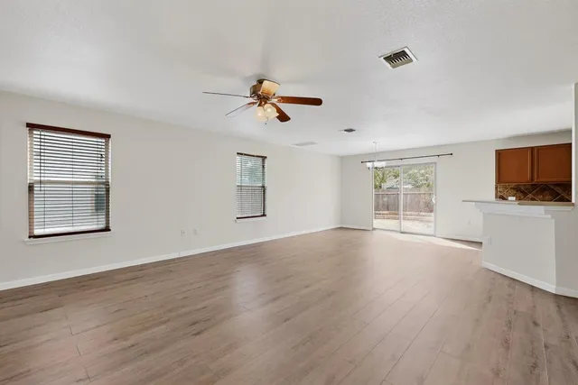 a view of room with hardwood floor and ceiling fan