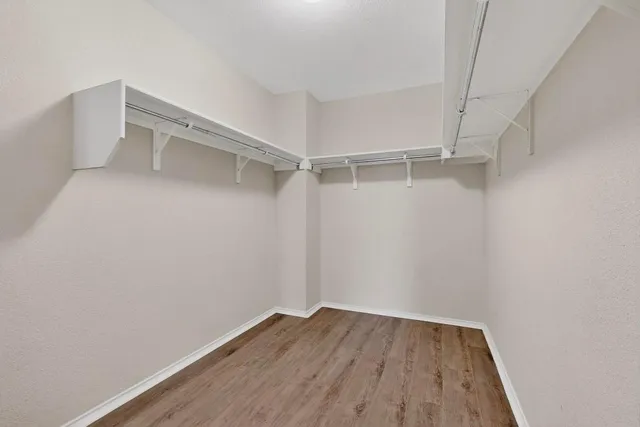a view of walk in closet with empty racks