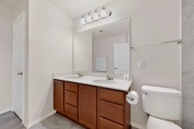a bathroom with a sink a toilet and mirror