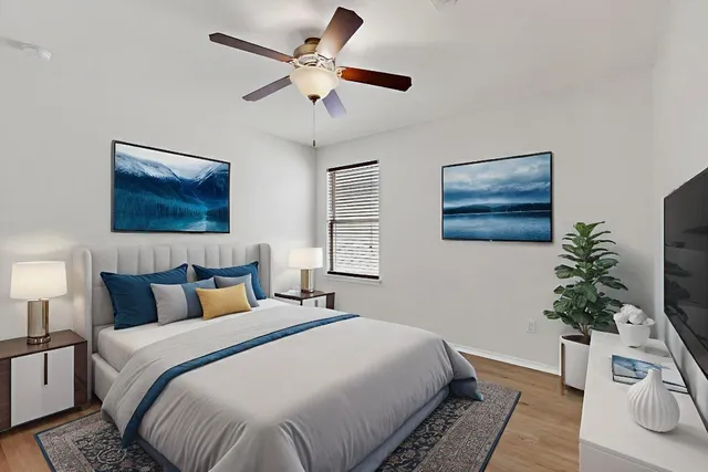 a bedroom with a large bed and a chandelier