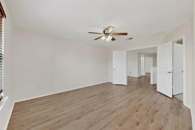 a view of room with hardwood ceiling fan and window