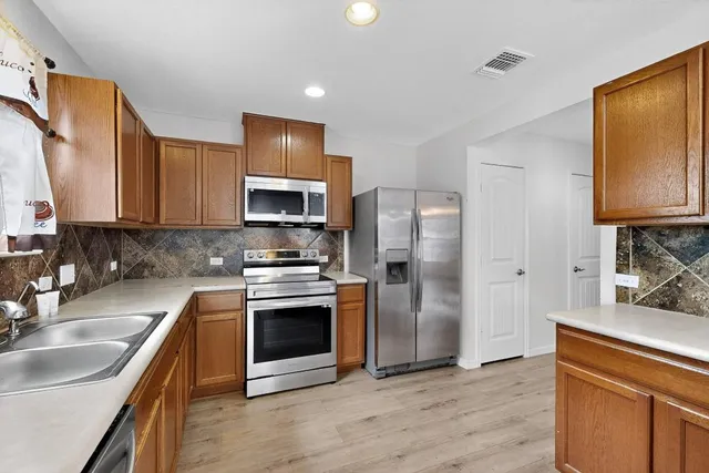 a kitchen with stainless steel appliances granite countertop a sink stove and refrigerator