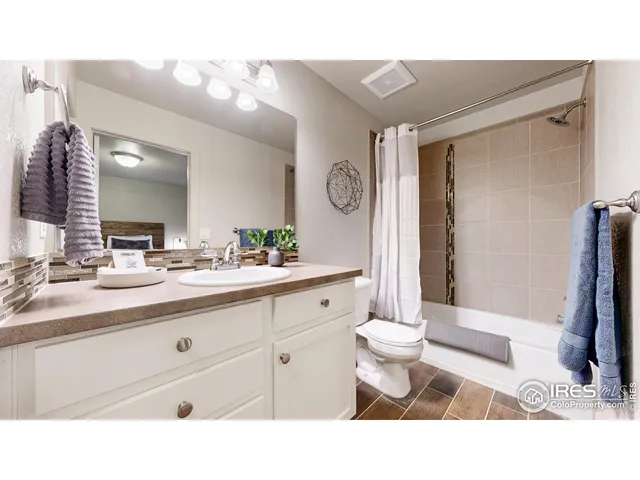 a bathroom with a sink a toilet a mirror and shower