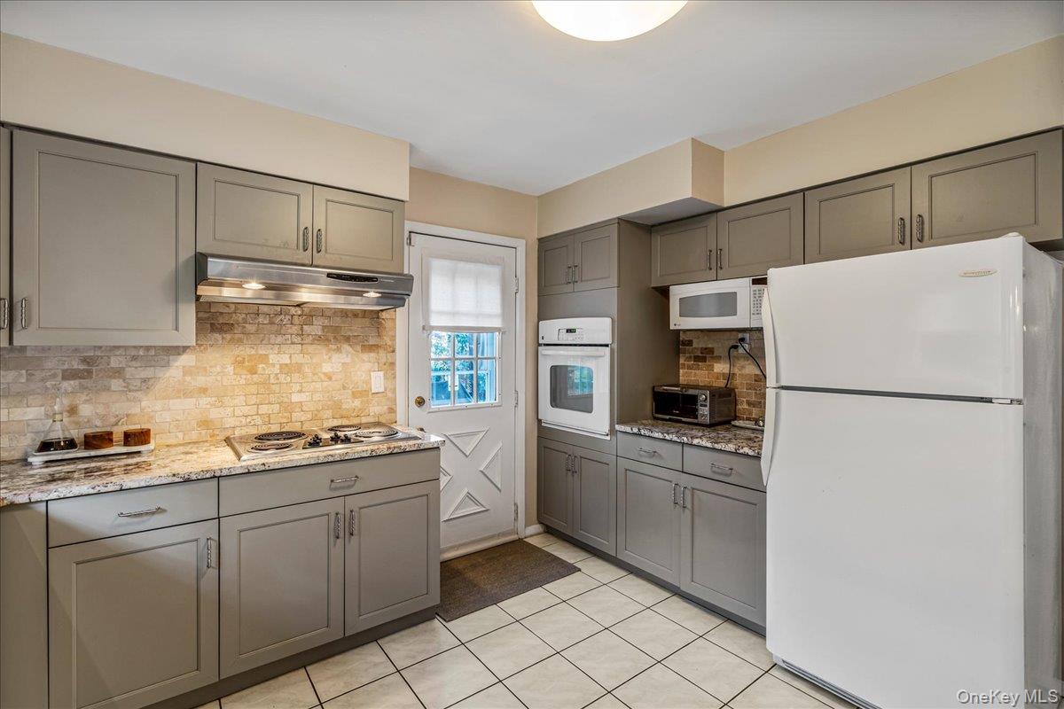 53 Stuart Place Manhasset, NY 11030 - Photo 14 of 32 a kitchen with white cabinets and white appliances