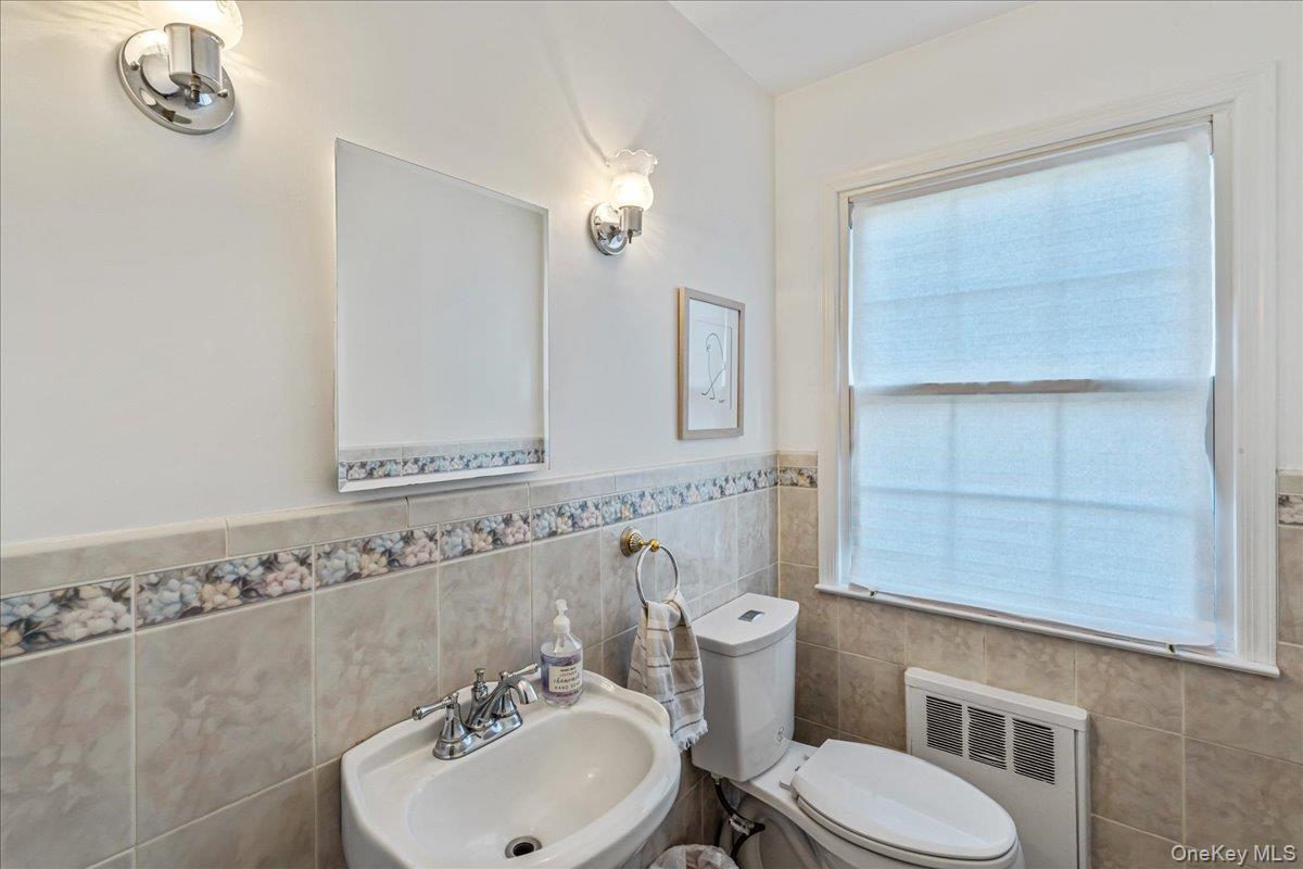 53 Stuart Place Manhasset, NY 11030 - Photo 15 of 32 a bathroom with a sink a toilet and a mirror