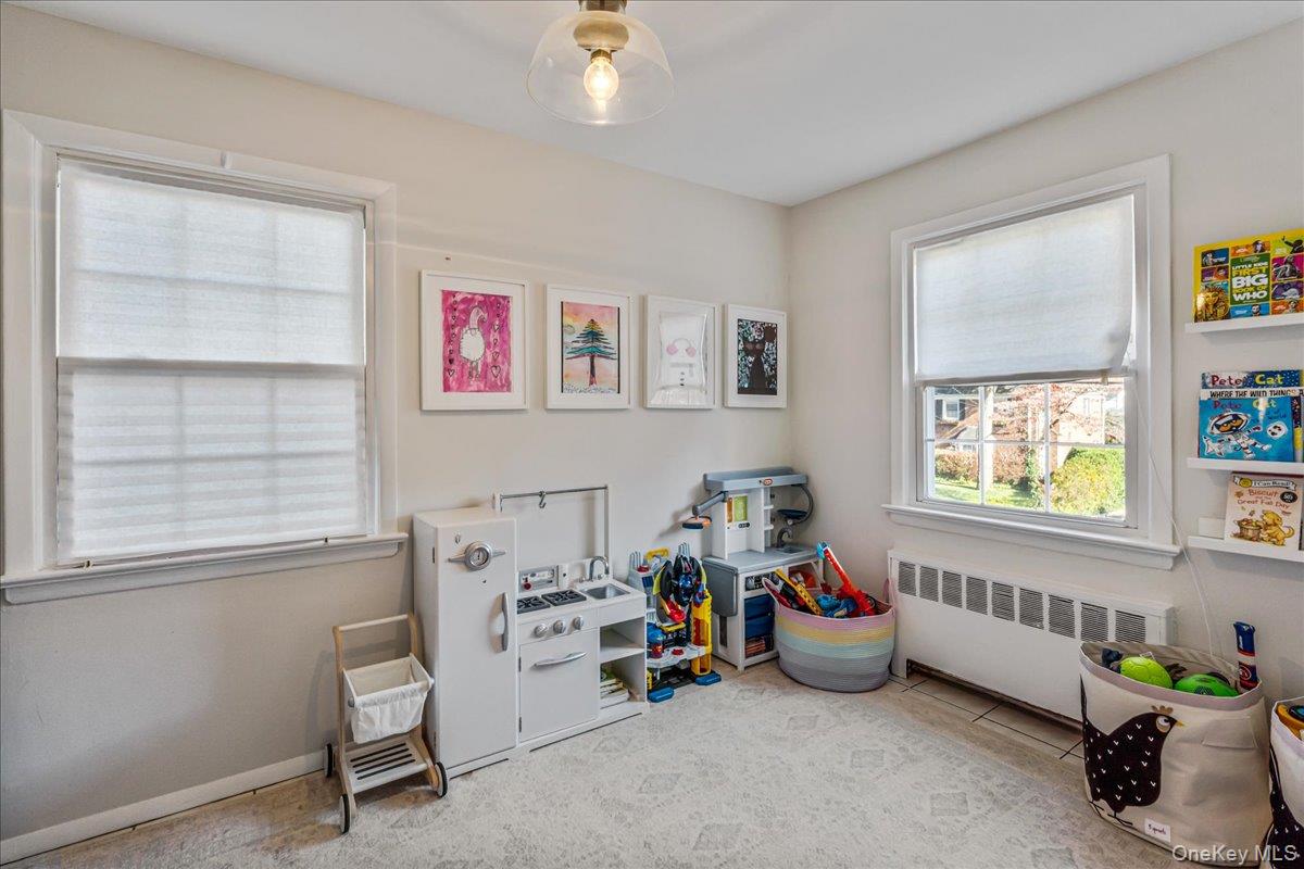 53 Stuart Place Manhasset, NY 11030 - Photo 16 of 32 a bedroom with furniture and a window