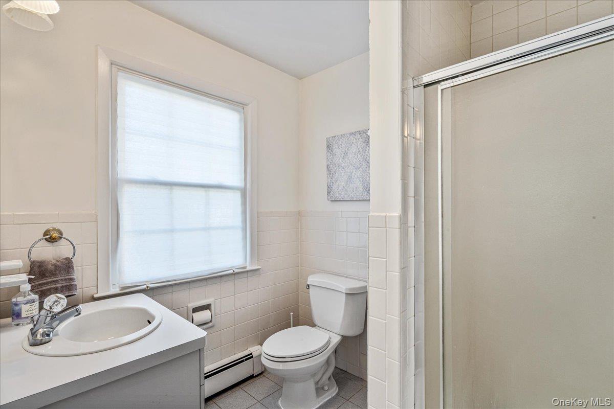 53 Stuart Place Manhasset, NY 11030 - Photo 19 of 32 a bathroom with a granite countertop sink toilet and a mirror