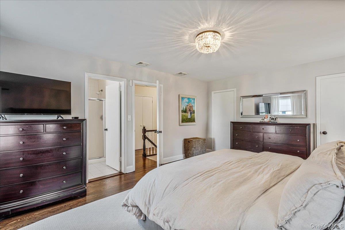 53 Stuart Place Manhasset, NY 11030 - Photo 21 of 32 a bedroom with a bed and a flat screen tv