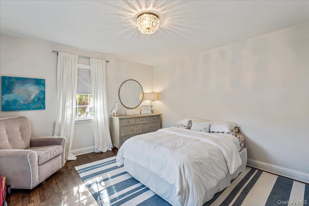 53 Stuart Place Manhasset, NY 11030 - Photo 22 of 32 a bedroom with a bed and a chandelier