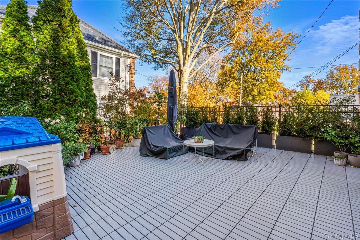 53 Stuart Place Manhasset, NY 11030 - Photo 27 of 32 a view of a patio with a table and chairs and potted plants