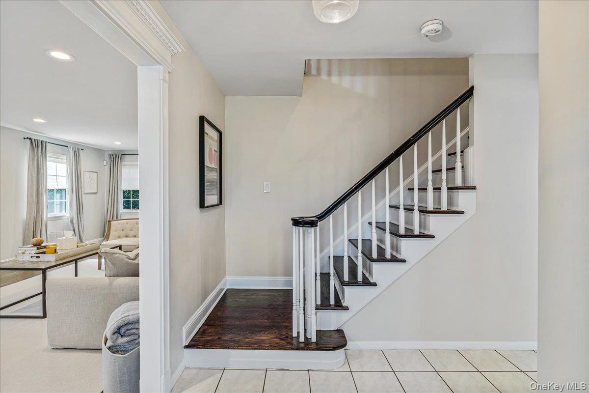 53 Stuart Place Manhasset, NY 11030 - Photo 6 of 32 a view of staircase with lots of frames and couches