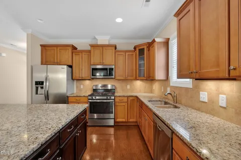 a kitchen with stainless steel appliances granite countertop a sink stove microwave and refrigerator