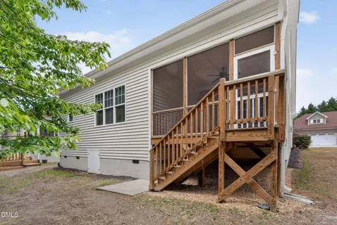 a view of a house with wooden deck and a backyard