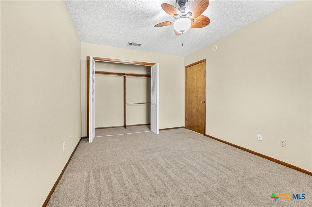 1015 Old Mill Road, Unit 4D Salado, TX 76571 - Photo 12 of 22 an empty room with a ceiling fan and carpet