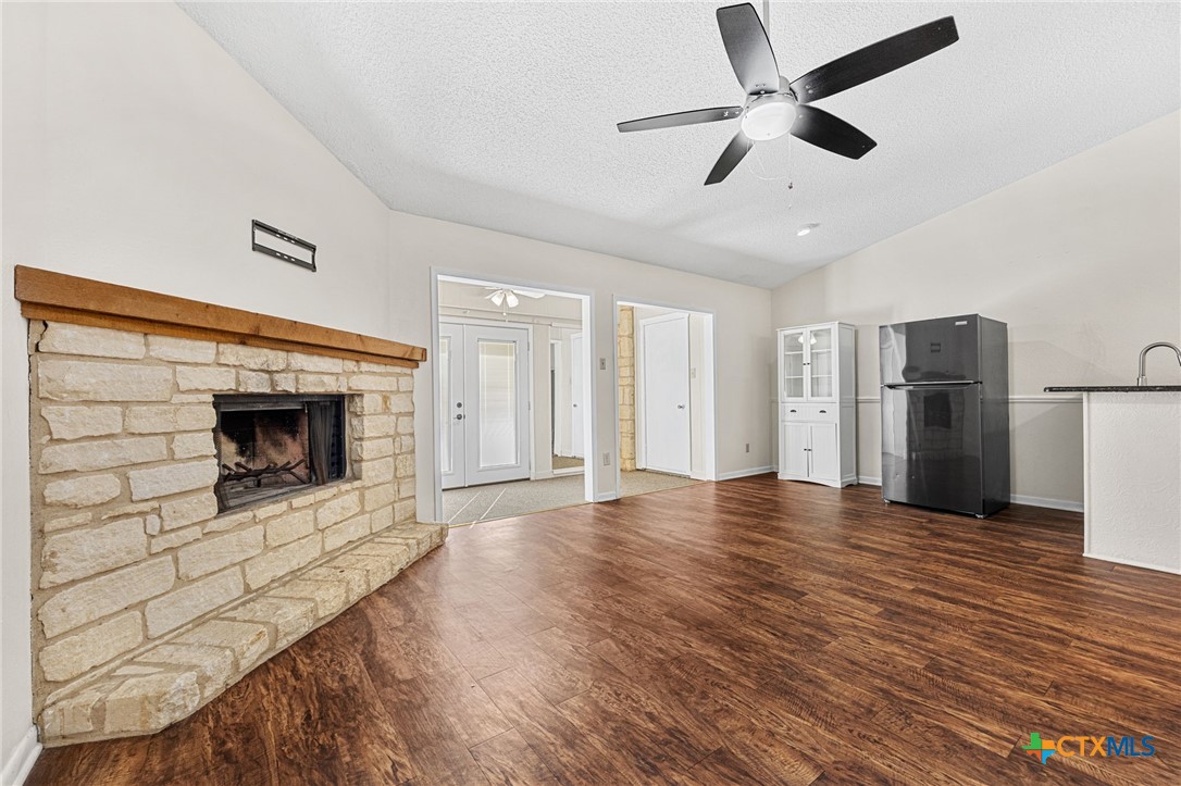 1015 Old Mill Road, Unit 4D Salado, TX 76571 - Photo 6 of 22 a view of a livingroom with a fireplace a ceiling fan and wooden floor