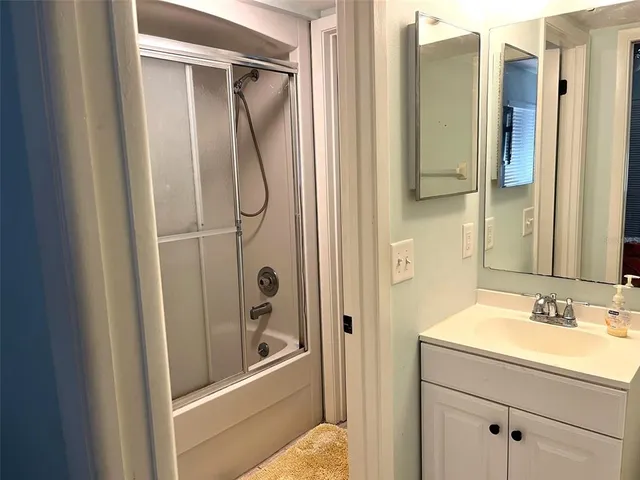 a bathroom with a granite countertop shower mirror and a sink