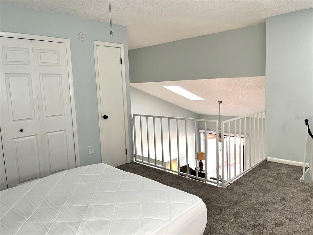 101 North Hill Avenue, Unit 7 Deland, FL 32724 - Photo 9 of 11 a bedroom with a bed and a chandelier