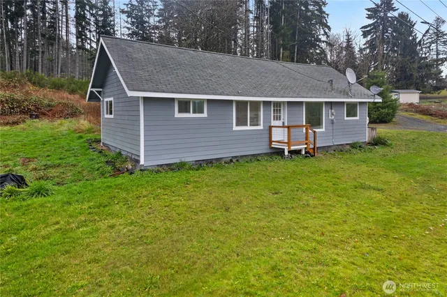 a aerial view of a house with a yard and large tree