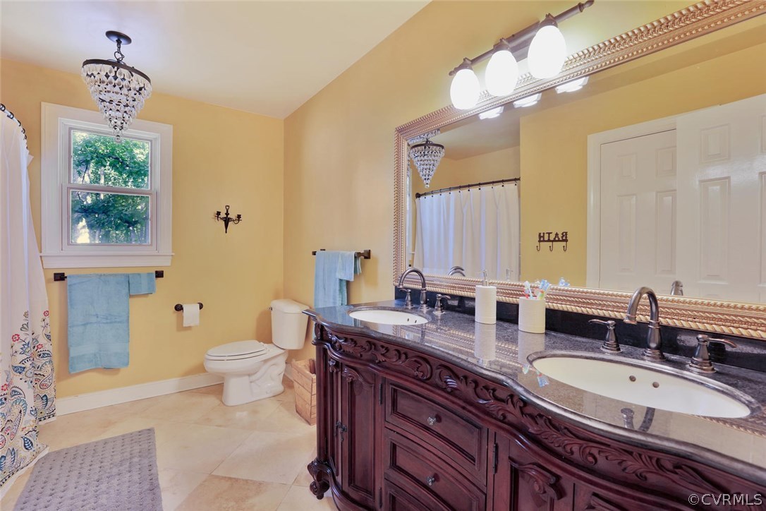 15900 Beach Road Chesterfield, VA 23838 - Photo 26 of 45 a bathroom with a granite countertop double vanity sink a toilet and a mirror