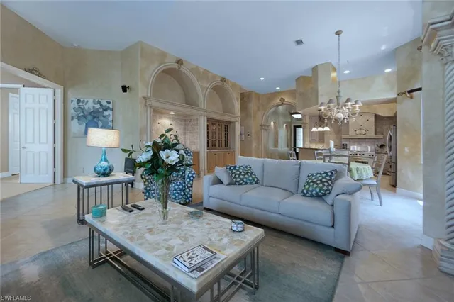a living room with furniture and a chandelier