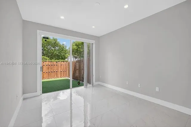 a view of a room with large windows and plants