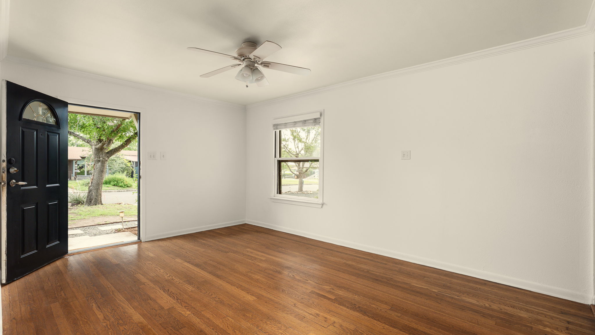 206 East Skyview Road Austin, TX 78752 - Photo 4 of 32 Rich hardwood floors welcome you into this light-filled entry space, offering immediate outdoor access.