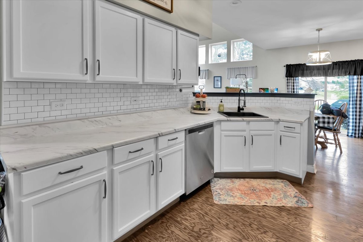 16501 Nottingham Court Lockport, IL 60441 - Photo 14 of 44 a kitchen with white cabinets appliances a sink and a window