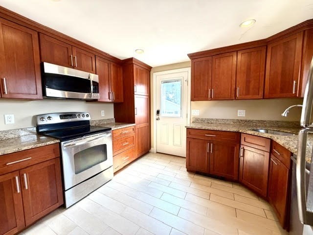 116 Upton Road Waltham, MA 02452 - Photo 3 of 22 a kitchen with stainless steel appliances granite countertop a stove microwave and sink