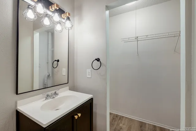 a bathroom with a sink a light fixture and a mirror
