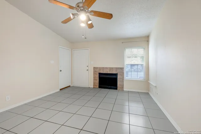 an empty room with windows and fireplace