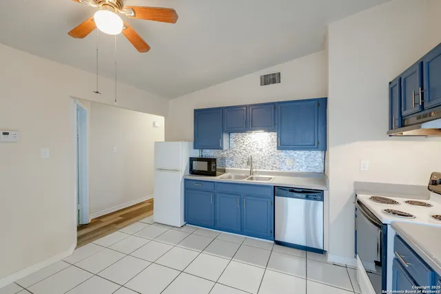 a kitchen with stainless steel appliances granite countertop a sink and a refrigerator