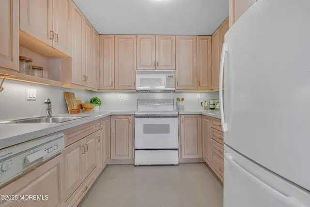 a kitchen with white cabinets and white appliances