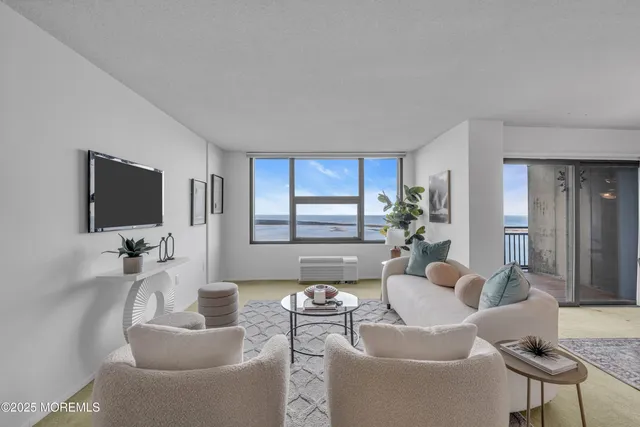 a living room with furniture a flat screen tv and a table
