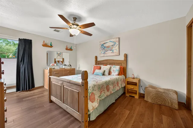 a spacious bedroom with a bed and a dresser