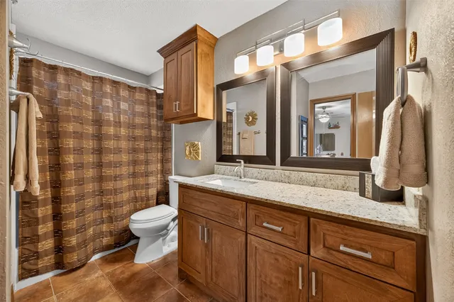 a spacious bedroom with a bed a couch and a flat screen tv