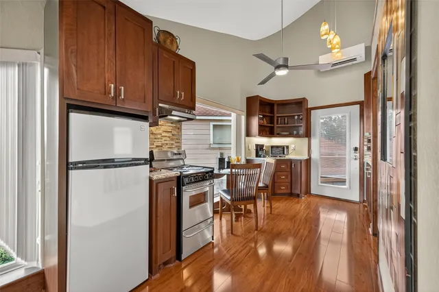 a view of a patio with couches and table and chairs with wooden floor and fence