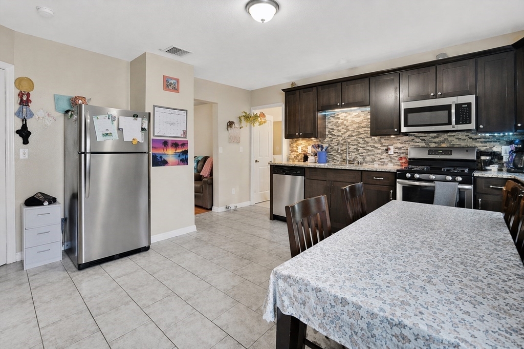 38 Whitman Street Chicopee, MA 01013 - Photo 17 of 29 a kitchen with stainless steel appliances granite countertop a refrigerator a stove a sink a microwave and island