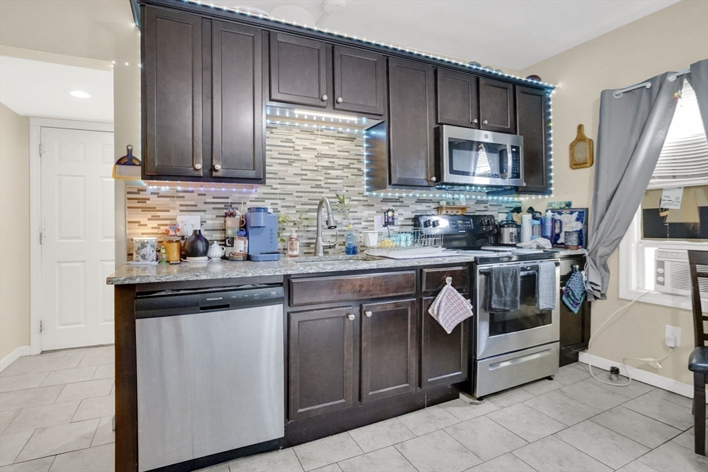 38 Whitman Street Chicopee, MA 01013 - Photo 19 of 29 a kitchen with stainless steel appliances granite countertop a stove a sink and a microwave