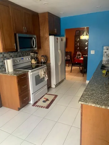 a kitchen with stainless steel appliances granite countertop a stove refrigerator and microwave