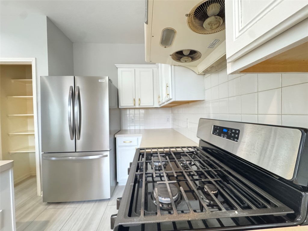 3404 Bratton Ridge Crossing Austin, TX 78728 - Photo 3 of 25 a kitchen with wooden cabinets and a stove top oven