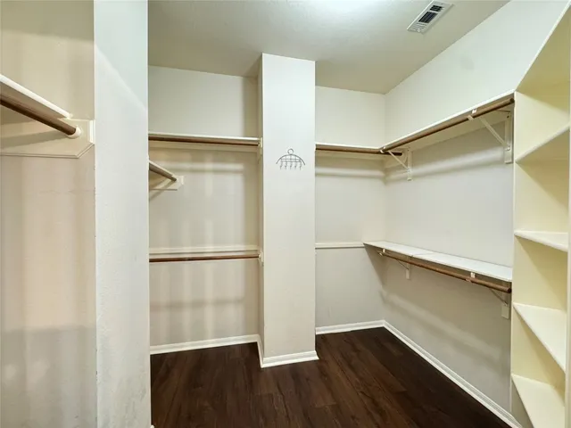 a view of walk in closet with empty racks